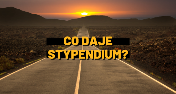 baner z napisem co daje stypendium na tle drogi i zachodzącego słońca